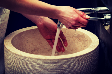 Woman cleaning hands in bathroom.の写真素材
