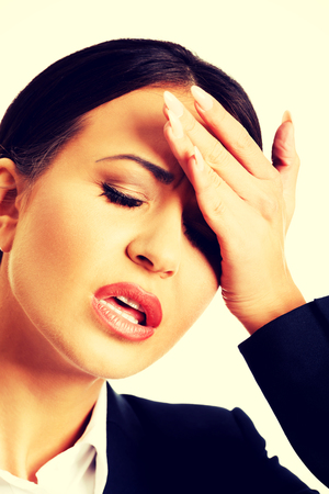 Tired businesswoman having huge headache.の写真素材