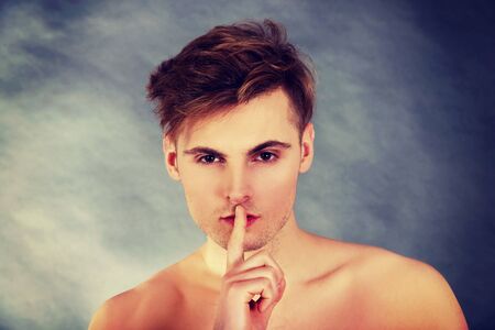 Young handsome man with finger on lips.の写真素材