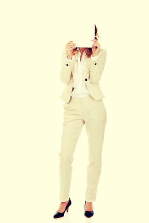 Businesswoman covering face with blank paper sheet.の写真素材