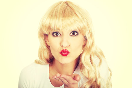 Attractive blonde woman blowing a kiss.の写真素材