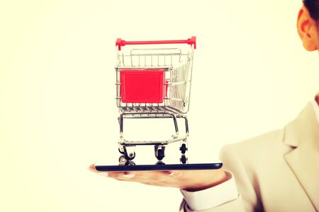 African businesswoman with shopping cart and tablet.の写真素材