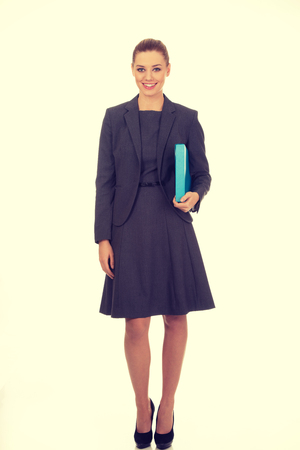 Happy businesswoman holding a binder.の写真素材