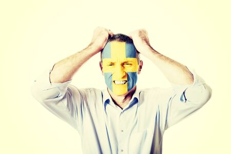 Mature man with Sweden flag painted on face.の写真素材