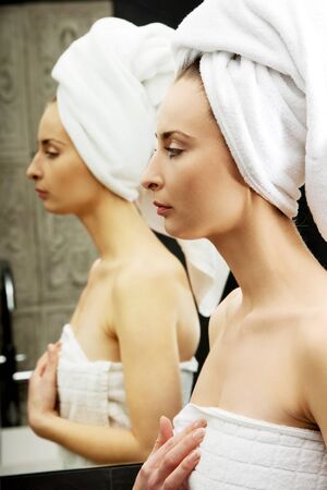 Beautiful woman wrapped in towel at bathroom.の写真素材