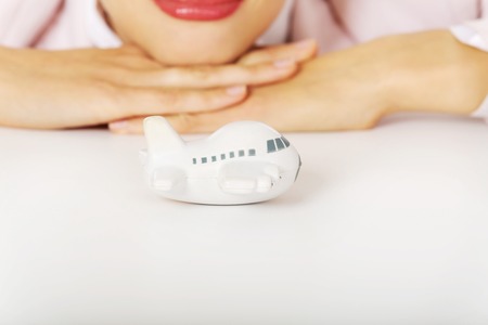 Closeup photo of business woman lying on the desk with toy plane.の写真素材