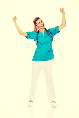 Young happy female doctor with hands up. Winning conceptの写真素材