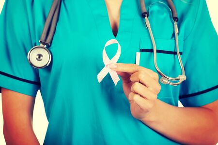 Nurse holding pink breast cancer awareness ribbon. Breast cancer concept.の写真素材