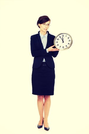 Beautiful business woman holding clock in hands.の写真素材
