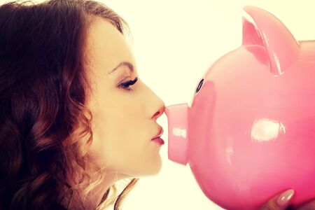 Happy business woman kissing a piggybank.の写真素材