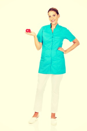 Young female doctor or nurse holding heart toy.の写真素材