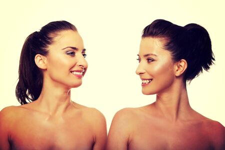 Two attractive topless sisters with make up.の写真素材