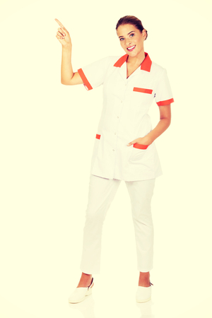 Smiling female doctor or nurse pointing at something.の写真素材