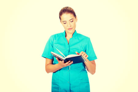 Young female doctor or nurse holding black notes.の写真素材