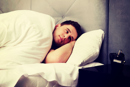 Handsome relaxing man lying in bed.の写真素材