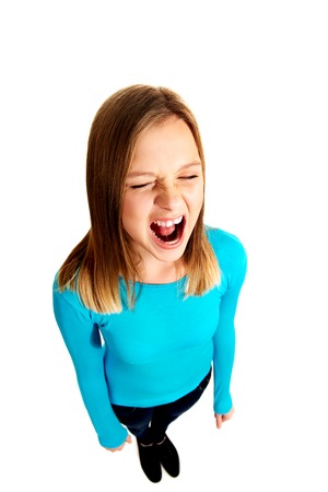 Angry young teen woman screamingの写真素材