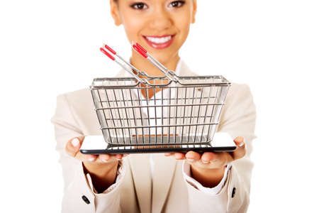 African businesswoman with shopping cart and tablet.の写真素材