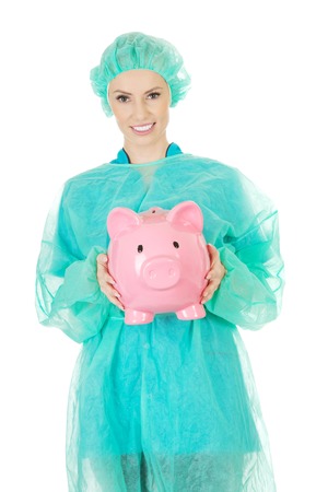 Female surgeon doctor with piggy bank.の写真素材