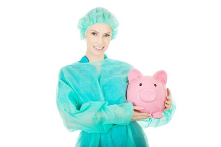 Female surgeon doctor with piggy bank.の写真素材