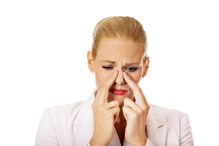 Young business woman with sinus pressure pain.