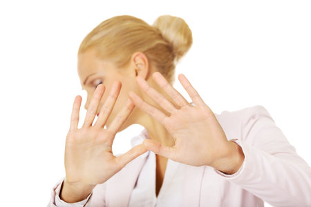 Young business woman trying to protect herself.の写真素材