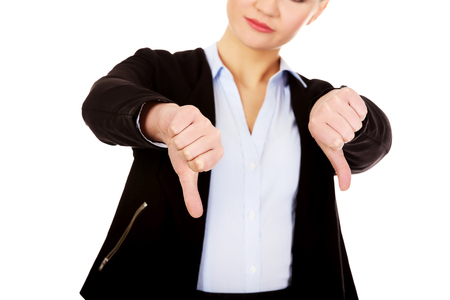 Unhappy businesswoman with thumbs down gesture.の写真素材
