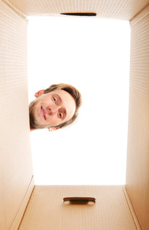 Happy young man looking inside box.