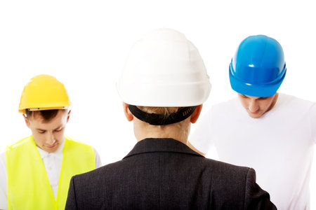 Female engineer talking with two builders.