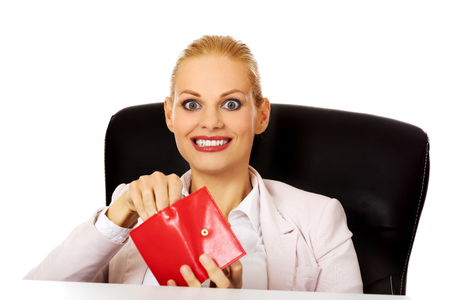 Smile business woman sitting behind the desk and holding wallet.の写真素材