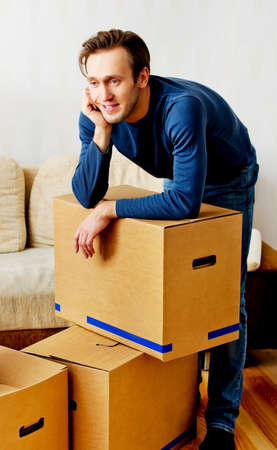 Young tired man based on carton box.の写真素材