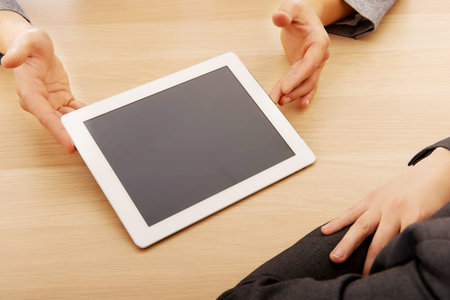 Business meeting-man showing something on tablet.