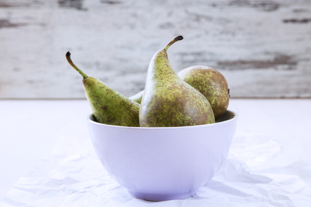 Three ripe pears in violet porcalain bowl.の写真素材