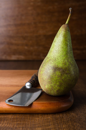 Pear and chopper on wooden cutting board.の写真素材