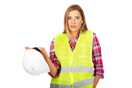 Angry female builder holding helmet.の写真素材