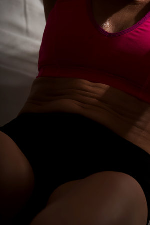 Young woman shows her muscles on stomach