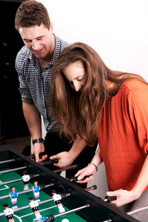 Friends having fun together playing table football.の写真素材