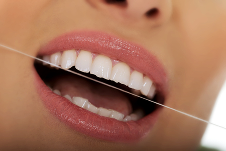 Beautiful woman using dental floss.の写真素材