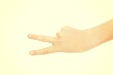 Woman hand shows two fingers - victory sign.の写真素材