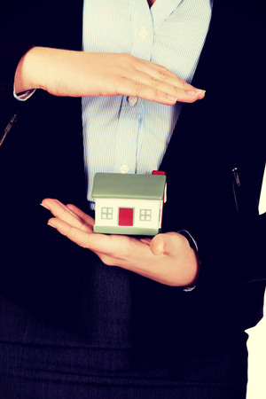 Beautiful business woman holding a model of house.の写真素材