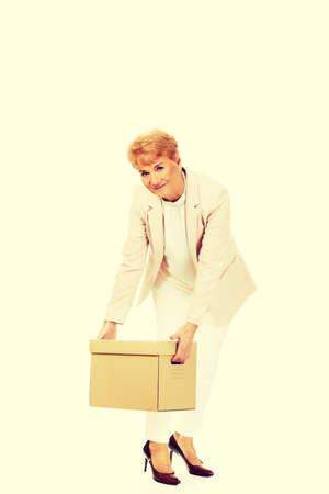 Smile elderly business woman holding cardboard box.の写真素材