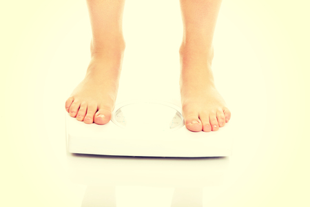 Slim woman's legs on scale.の写真素材