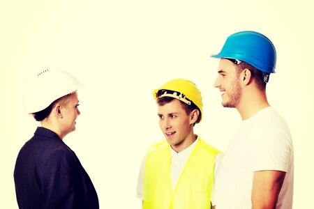 Female engineer talking with two builders.の写真素材