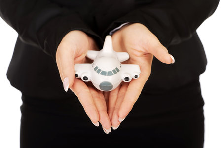 Businesswoman presenting plane model in hand.の写真素材