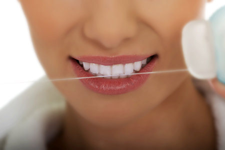 Beautiful woman using dental floss.