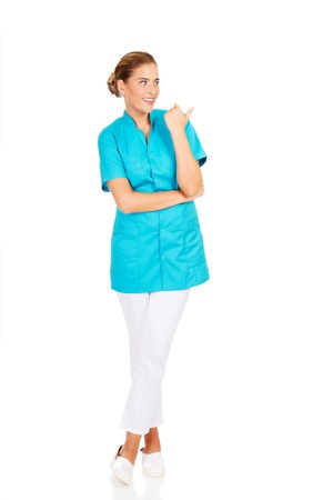 Young female doctor showing something by thumb.の写真素材