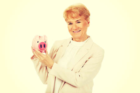 Smile elderly woman holding piggy bank.の写真素材