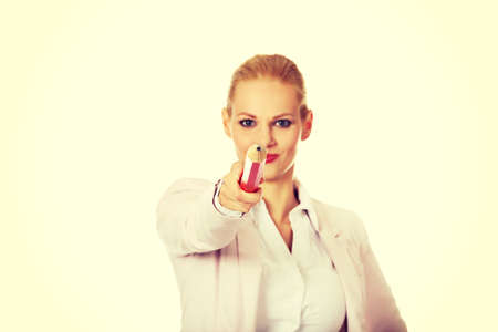 Attractive business woman pointing on camera with oversized pen.の写真素材