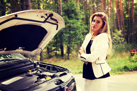 Woman opened the hood broken car.