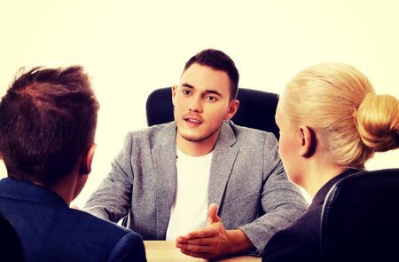 Business meeting - three people sitting and talking.の写真素材