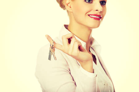 Business woman real estate agent holding keys.の写真素材